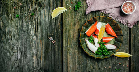 Fresh Sliced Crab Stick Slices Surimi on Wooden Board. Ready to Eat. Long banner format. top view.の写真素材