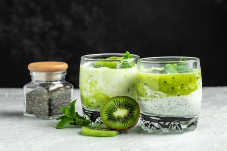 Chia pudding in a glass. Healthy breakfast. chia pudding with kiwi on dark background. Long banner format. top view.の写真素材