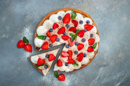 Delicious cake pie tart with fresh strawberries, raspberries, blueberry on gray background. banner,...