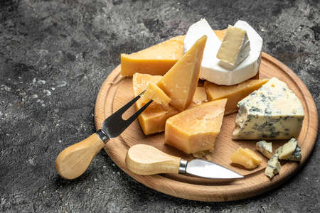 Parmesan. Different types of cheese with knife on a dark background. place for text, top view.