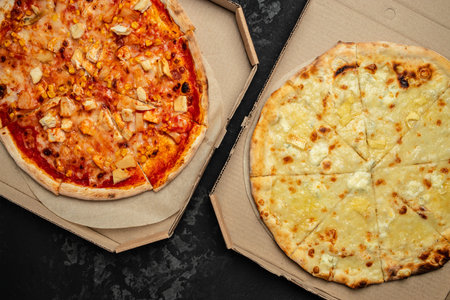 Tasty hawaiian pizza with chicken and pineapple pizza Four Cheeses on a dark background.の写真素材