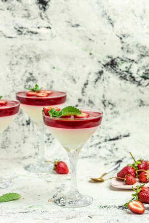 Sweet strawberry mousse with organic yoghurt. Fresh fruit dessert decorated with mint topping with strawberry sauce. Italian dessert, vertical image. top view. place for text.の写真素材