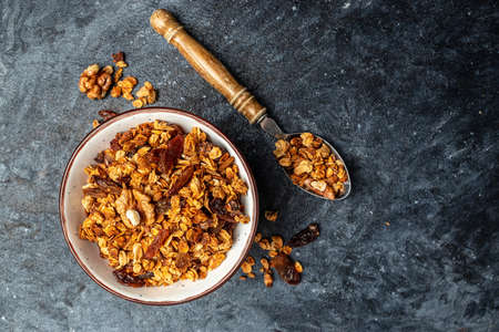 Bowl with granola on a dark background. superfood concept. Healthy, clean eating. Vegan or gluten free diet. Long banner format. top view.の写真素材