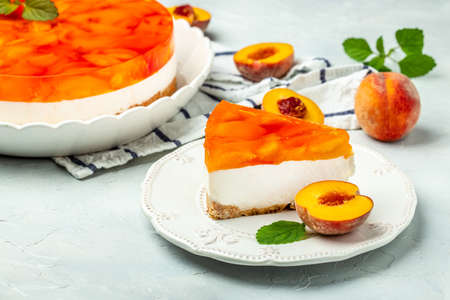 dessert peaches, cheesecake with peache jelly on white plate. Restaurant menu, dieting, cookbook recipe top view.の写真素材