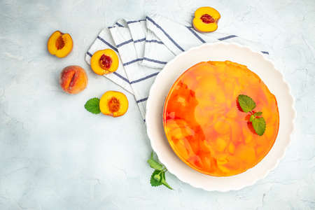 cheesecake with peaches, peache jelly, jam on a light background. banner, menu, recipe place for text, top view.の写真素材