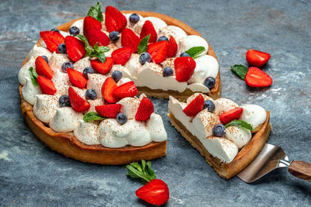 piece of tasty cake pie tart with fresh strawberries, raspberries, blueberry with shovel. Restaurant menu, dieting, cookbook recipe top view.の写真素材