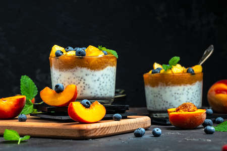 homemade dessert with fruits, parfait yogurt with peaches blueberry and chia. place for text.の写真素材