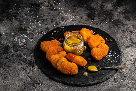 Fried crispy chicken nuggets with mustard honey sauce on stone board, american unhealthy calories meal. Delicious pub style, appetizer, restaurant menu, top view,の写真素材