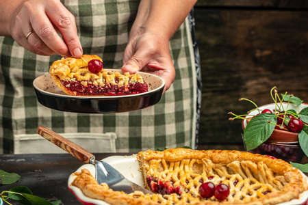 Woman with tasty cherry pie. One piece on a plate and the whole homemade cherry pie.の写真素材