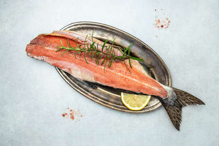 Fresh raw salmon red fish. fillet with rosemary and salt. on a light background. place for text, top view.の写真素材