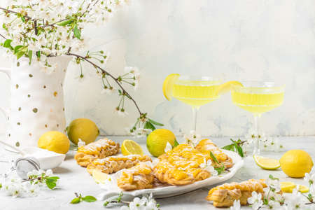 Limoncello. Traditional italian homemade alcoholic drink in glass with pieces of lemon, sweet Italian lemon liqueur on a light background. Long banner format. top view.の写真素材