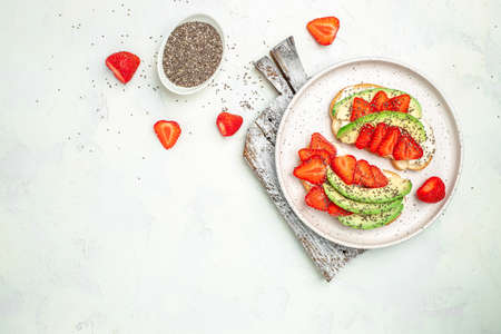 Healthy breakfast sandwiches with avocado strawberries, soft cheese, chia seeds, gluten free diet, place for text, top view,の写真素材