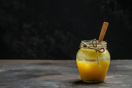 Homemade Melted ghee clarified butter. Bio Ayurveda Lactose free high quality butter on a dark...