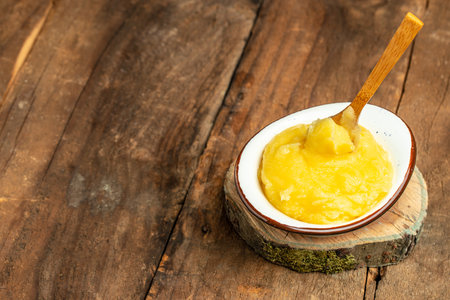 Homemade ghee Pure desi ghee in a bowl with wooden spoon, Healthy fats, clean eating for weight loss. place for text, top view.の写真素材