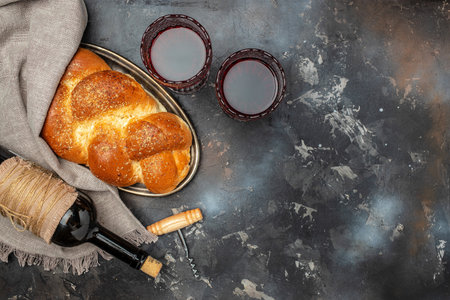 Shabbat Shalom challah bread, shabbat wine on a dark background, place for text, top view,の写真素材