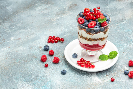 yogurt granola parfait with blueberry and raspberry on a light background. Long banner format.の写真素材