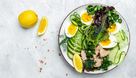 Tuna vegetable vegetarian buddha bowl avocado, egg, cucumber and fresh salad on a light background. top view.の写真素材