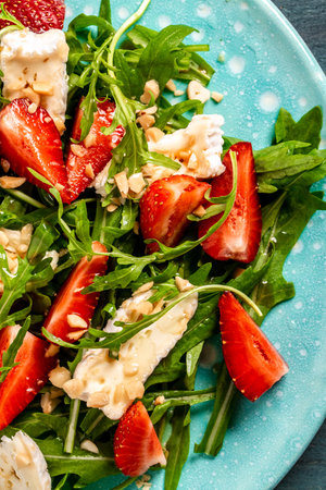 Salad strawberry, aragula and brie, camembert cheese. Concept vegan and eating healthy. top view. Diet dinner or lunch menu.の写真素材