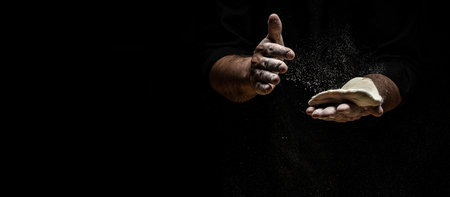 Hands of baker kneading dough isolated on black background. prepares ecologically natural pastries. Long banner format.の写真素材