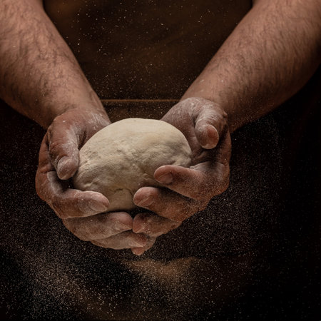 man kneading dough, baker with flour. Beautiful and strong men's hands knead the dough make bread,...