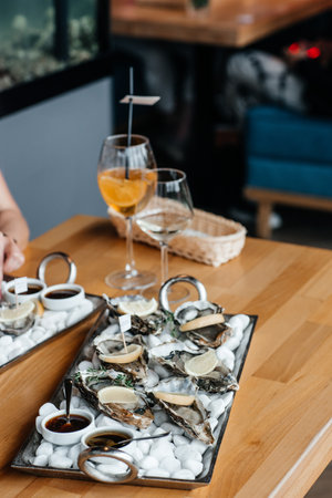Fresh oysters with lemon. raw opened oyster, lifestyle food, ready to eat. Oyster dinner with champagne in restaurant.の写真素材
