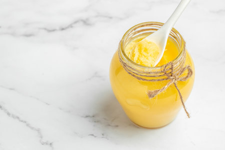 Homemade Melted ghee clarified butter. Bio Ayurveda Lactose free high quality butter on a light...