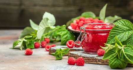 Homemade raspberry jam in jar with raspberries and mint. Long banner format. place for text.の写真素材