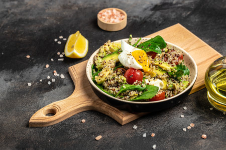 Keto diet plate quinoa, avocado, egg, tomatoes, spinach and sunflower seeds on light background. Healthy food, ketogenic diet, diet lunch concept, place for text, top view.の写真素材