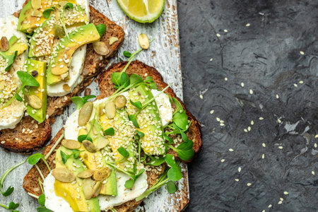 toasts with rye bread, sliced avocado, cheese. Delicious breakfast or snack, Clean eating, dieting, vegan food concept. top view.の写真素材