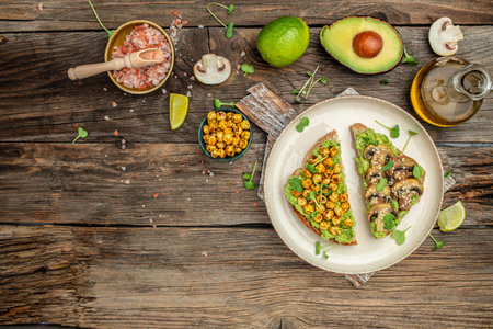 toasts with guacamole and mushrooms, chickpea on a wooden background. Clean eating, dieting, vegan...
