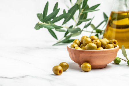 Branch with olives and a bottle of olive oil on white background. top view. place for text,の写真素材