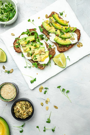 avocado toasts with cheese, pumpkin, nut and sesame. Healthy fats, clean eating for weight loss.