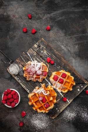 Belgian waffles with raspberries with sugar powder, Delicious breakfast or snack.vertical image. top view. place for text,の写真素材