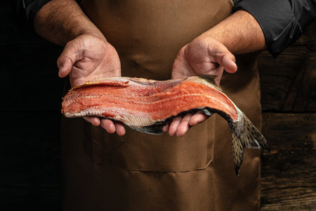 salmon in hands. Chef's hand holding fresh fillet of salmon, banner, menu, recipe place for text,