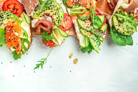 Open sandwich set with cream cheese, prosciutto, salmon, avocado and fresh greens. Keto, ketogenic diet, low carb, high good fat, healthy food. top view. place for text.の写真素材