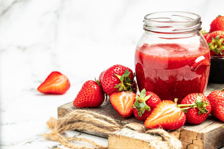Jar of strawberry jam and fresh berries on white background. Homemade strawberry marmalade and fruits.の写真素材