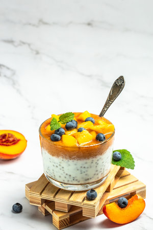 Healthy chia pudding with yogurt and fruit Peach and blueberry. Homemade dessert with fruits. place for text, top view.の写真素材