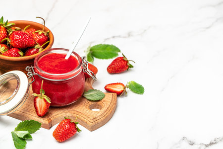 Jar of strawberry jam on white background. Homemade strawberry marmalade and fruits. Long banner format.の写真素材