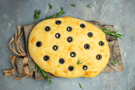 homemade focaccia bread baking with seasonings on a wooden board. top view. place for text.の写真素材