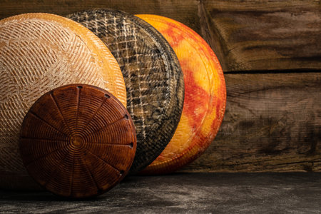 Big yellow goat cheese heads on a wooden board.の写真素材