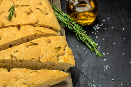 foccacia bread. olive oil and herbs on a dark background. banner, menu, recipe place for text, top view.の写真素材