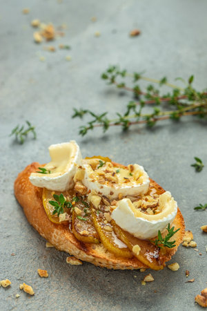 Appetizer bruschetta with pear, honey, walnut and thyme, New Years Eve or Christmas party, vertical image. top view. place for text,の写真素材