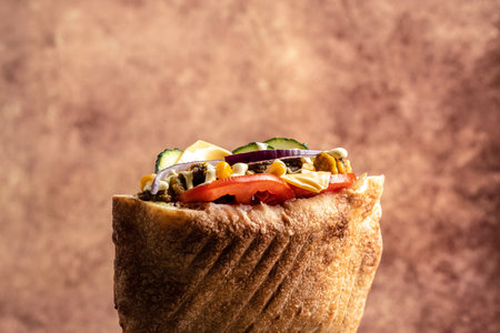 Greek gyros wrapped in pita breads with vegetables and sauce. traditional american food. fast food