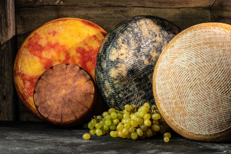 cheese at farmers traditional market. Big yellow goat cheese heads on a wooden board.