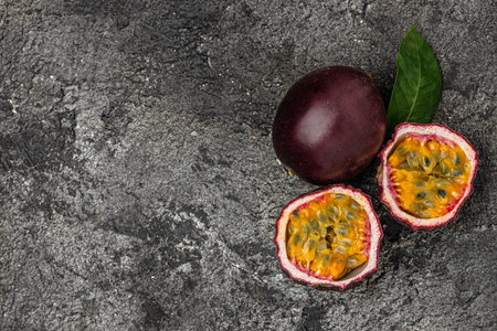 Passion fruits on dark background. Set of whole and half of fresh passion fruit. place for text, top view.の写真素材