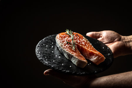 chef hands prepare fresh salmon steak fish. marinated salmon. Salmon steak raw fish and ingredients prepared for cooking. concept for eating and healthy.の写真素材