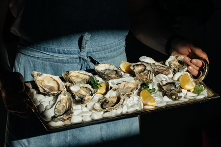 oyster. man eating shellfish. Seafood and Mediterranean cuisine with mussels in shell. oyster in luxury restaurant.の写真素材