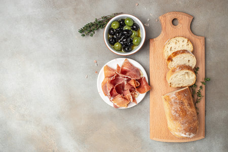 Delicious appetiser Italian prosciutto and Spanish Iberian ham snack bread ciabatta and olives. banner, menu, recipe place for text, top view.の写真素材