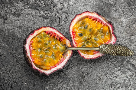 Passion fruits on dark background. Set of whole and half of fresh passion fruit. place for text, top view.の写真素材