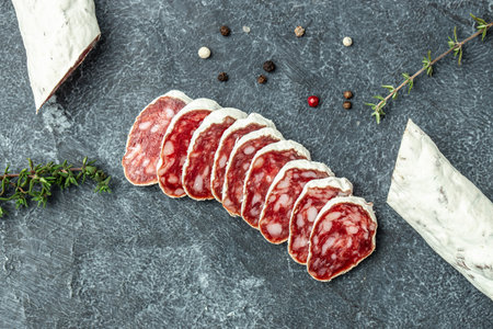 Sliced spanish sausage fuet. spanish dry cured sausage on a dark background. banner, menu, recipe...